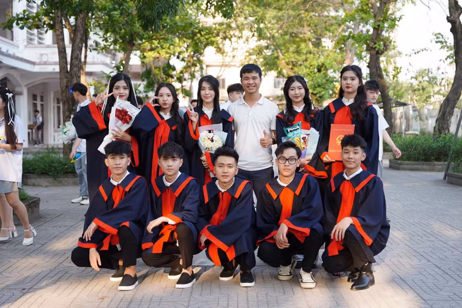 Thầy giáo Nguyễn Cao Thiện chụp ảnh kỷ yếu cùng học sinh lớp 12.