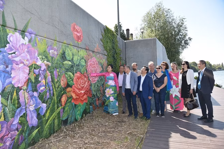 Họa sĩ Nguyễn Thu Thủy giới thiệu bức tranh trong lễ khánh thành.