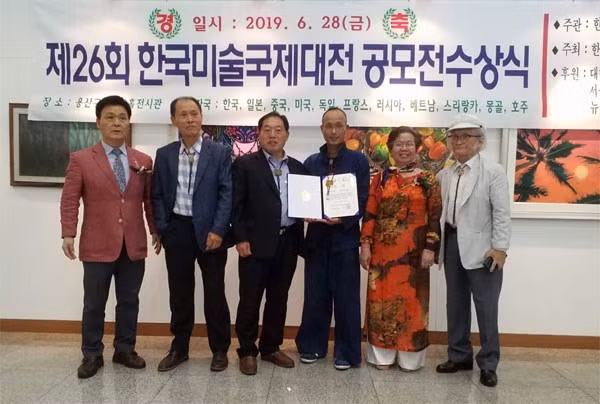 Họa sĩ Duy Hiển (nhận bằng chứng nhận Huy chương đồng), cùng họa sĩ Phan Thị Thanh Mai và các đồng nghiệp.