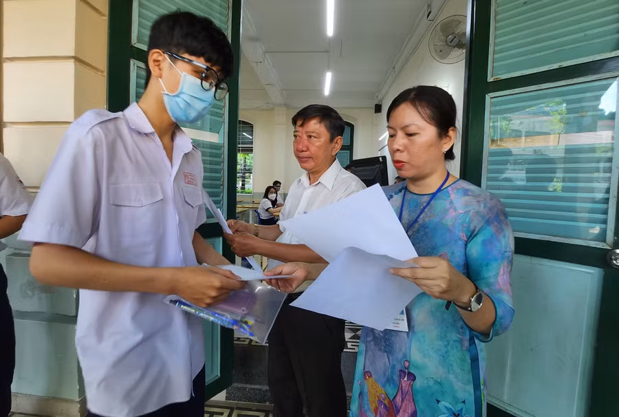 Cán bộ coi thi tại điểm thi Trường THPT Lê Quý Đôn gọi tên thí sinh vào phòng thi.