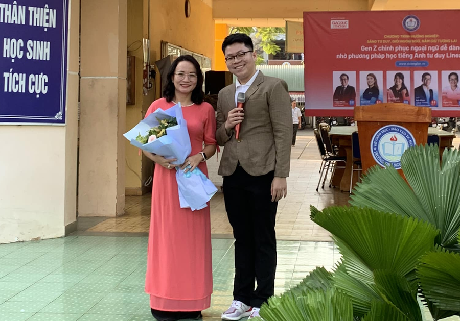 Diễn giả Anh Minh - đại diện DOL IELTS Đình Lực gửi tặng bó hoa đến BGH Nhà trường THPT Nguyễn Huệ.