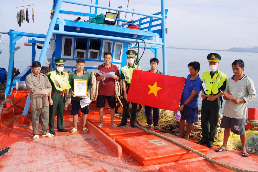 Cán bộ Biên đội III/22, Hải đoàn Biên phòng 18 trao tặng cờ Tổ quốc, phát tờ rơi tuyên truyền cho ngư dân.