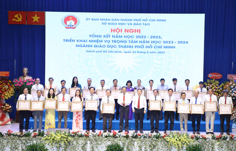 Thứ trưởng Phạm Ngọc Thưởng (hàng đầu thứ 8 từ trái qua) và ông Dương Anh Đức (hàng đầu thứ 7 từ phải qua) trao Bằng khen của UBND TPHCM cho các tập thể.