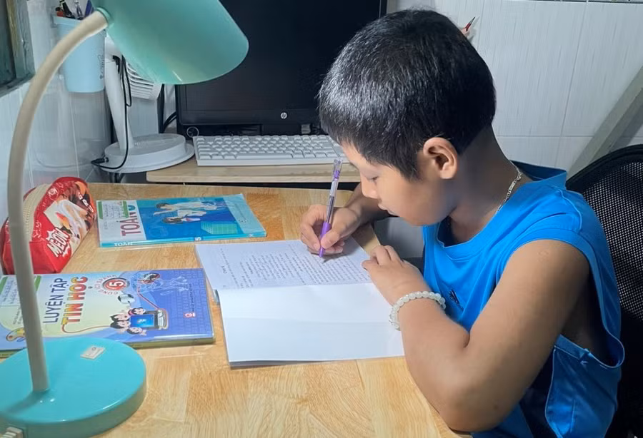 Nguyễn Tấn Đạt học bài buổi tối.