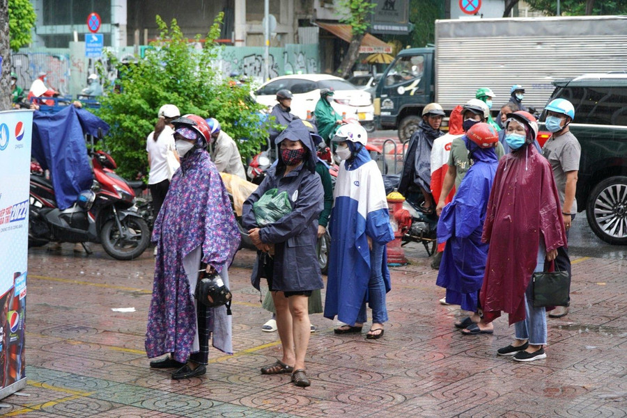 Phía ngoài cổng trường, hàng trăm phụ huynh mặc áo mưa đứng đợi các thí sinh.
