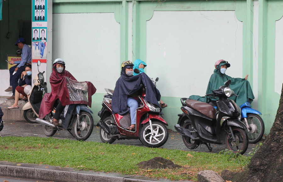 Tại cổng trường THCS Võ Trường Toản (quận 1), nhiều phụ huynh mặc áo mưa chờ con vào trong trường làm thủ tục dự thi.