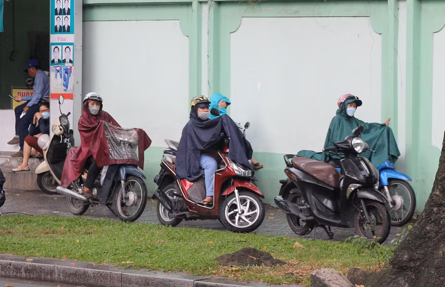 Tại cổng trường THCS Võ Trường Toản (quận 1), nhiều phụ huynh mặc áo mưa chờ con vào trong trường làm thủ tục dự thi.