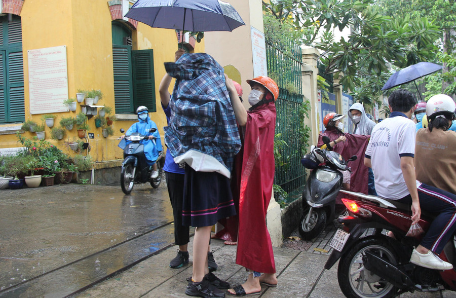 Thí sinh tại điểm thi Trường THPT Trưng Vương được phụ huynh đón tại cổng trường sau khi kết thúc buổi sinh hoạt quy chế thi.