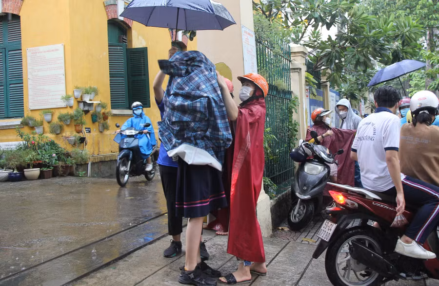 Thí sinh tại điểm thi Trường THPT Trưng Vương được phụ huynh đón tại cổng trường sau khi kết thúc buổi sinh hoạt quy chế thi.