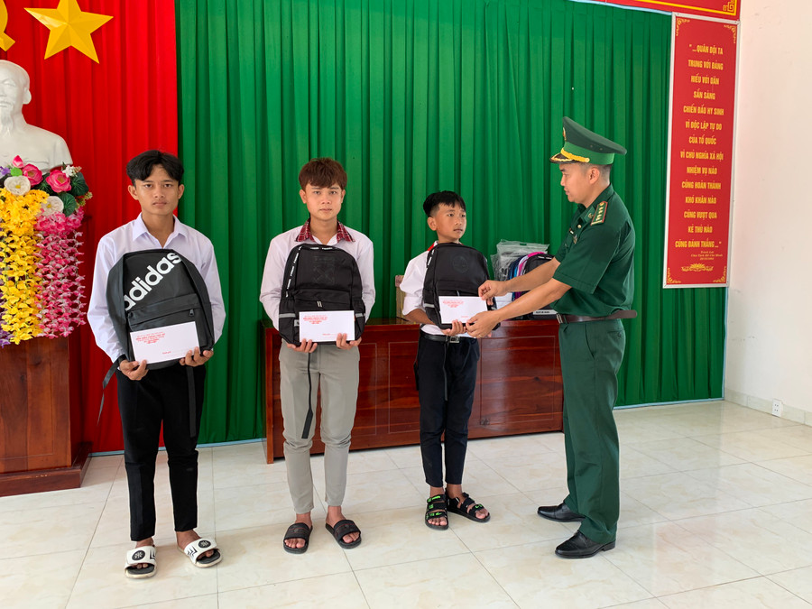 Cán bộ đồn Biên phòng Phú Mỹ trao học bổng và tặng quà cho học sinh nghèo.