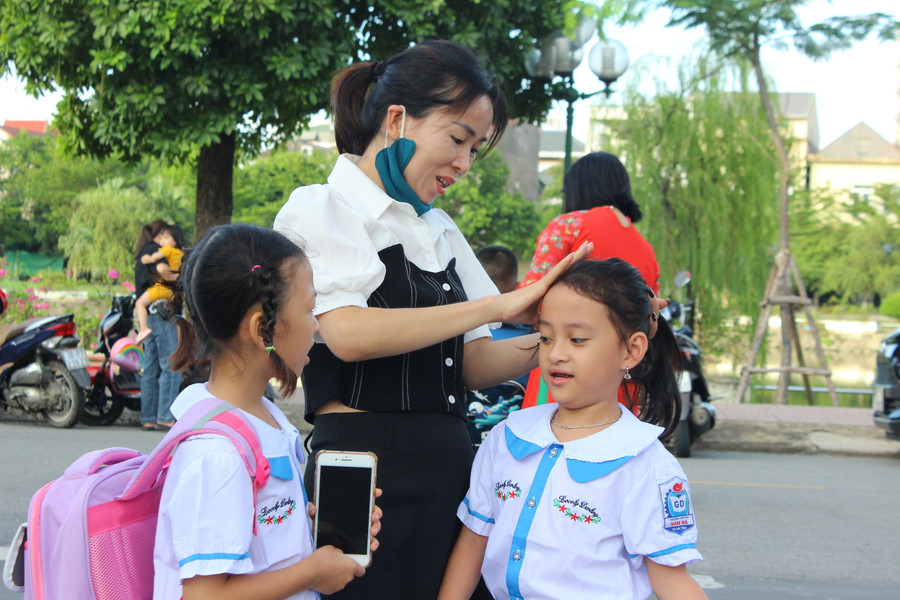 Phụ huynh sửa soạn cho con trước khi bước vào trường. Phụ huynh sửa soạn cho con trước khi bước vào trường.