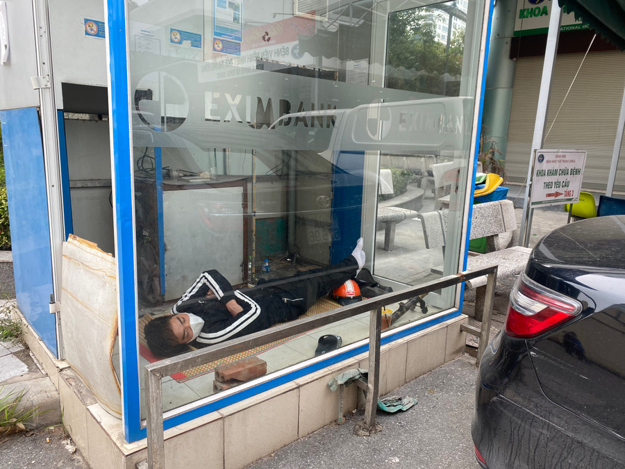 Mọi góc khuất gió đều được tận dụng để trở thành nơi trốn rét. Trong ảnh: Một người đàn ông nằm ngủ trong bốt rút tiền tự động chiều ngày 25/1.