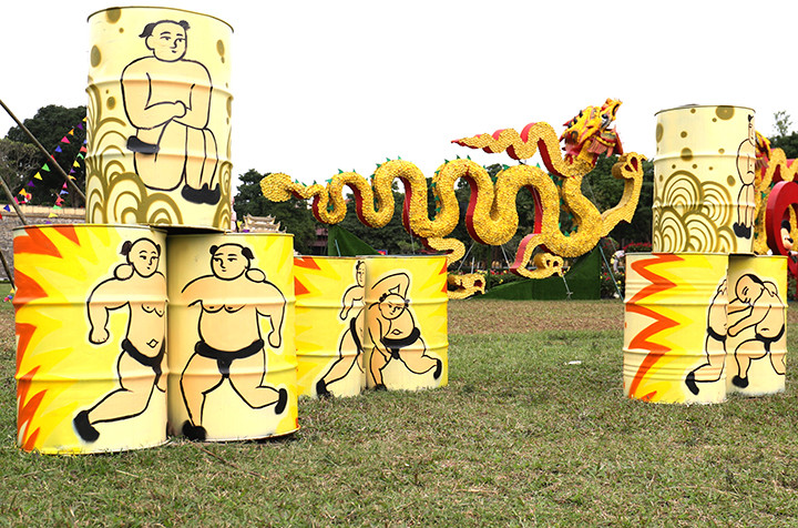 Bên cạnh đó còn không gian sắp đặt ngoài trời còn được thể hiện một cách biến hóa, bay bổng bằng nhiều cụm trang trí nổi bật với nón, đèn lồng, chong chóng, câu đối và chữ viết.