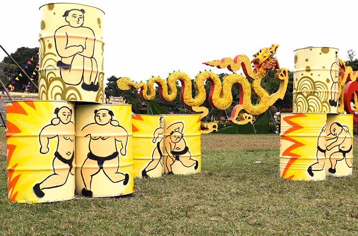 Bên cạnh đó còn không gian sắp đặt ngoài trời còn được thể hiện một cách biến hóa, bay bổng bằng nhiều cụm trang trí nổi bật với nón, đèn lồng, chong chóng, câu đối và chữ viết.