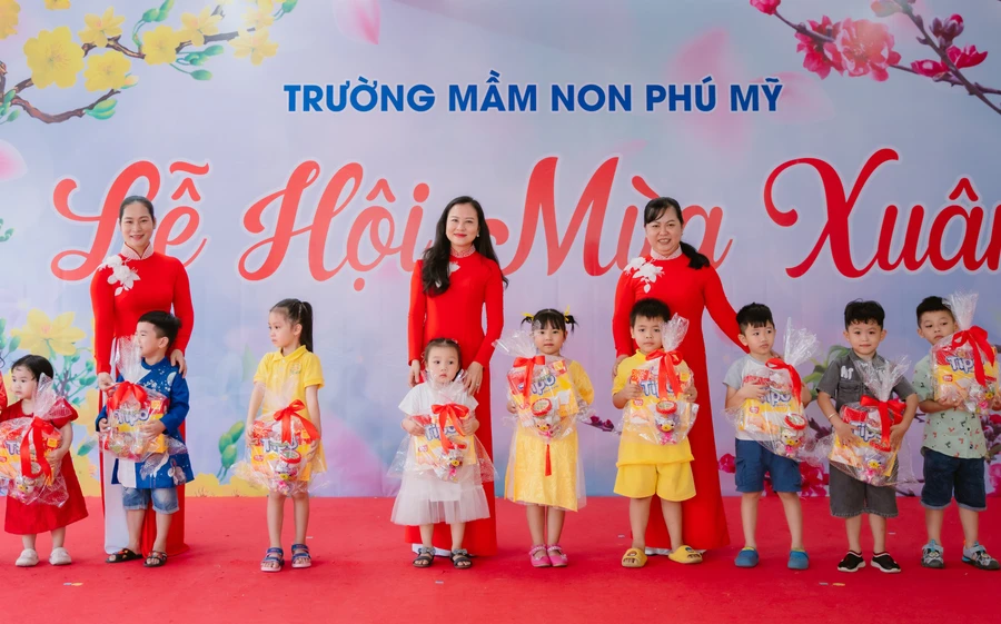 Cô Phạm Bảo Hạnh (ở giữa) cùng đồng nghiệp tặng quà cho học sinh khó khăn dịp Tết Nguyên đán.