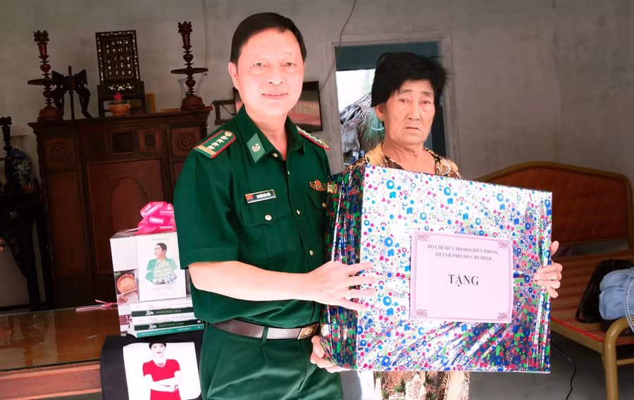 Đại tá Nguyễn Văn Tiến, Phó Chính uỷ Bộ đội biên phòng TP Hồ Chí Minhtặng quà cho gia đình bà bà Lê Thị Tôn.