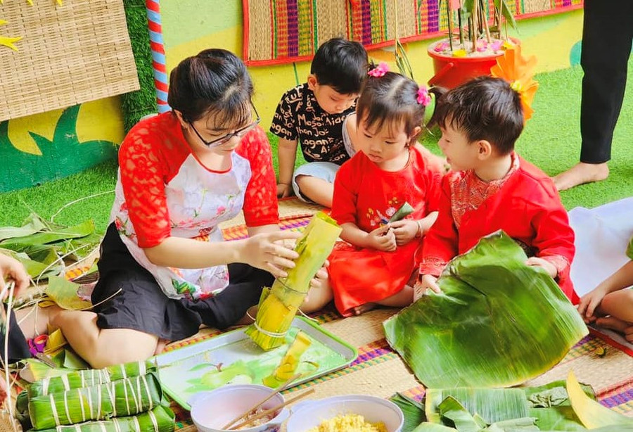 Giáo viên và trẻ Trường mầm non 19 Tháng 5 (quận 12) gói bánh chưng, bánh tét ngày Tết.