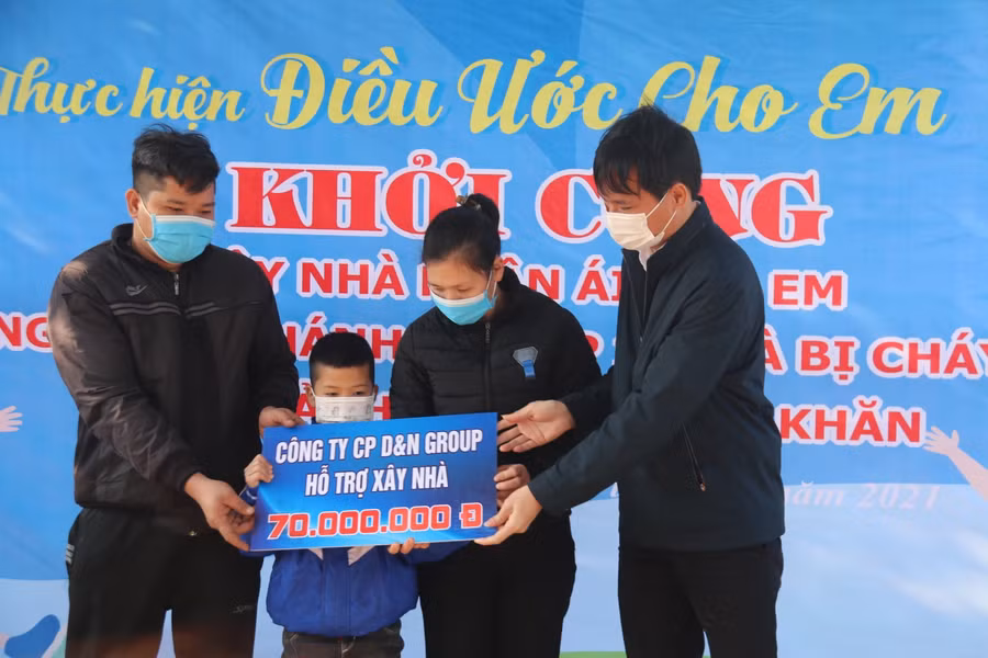 Ông Bùi Giang Nam, Giám đốc Công ty Cổ phần D&amp;N trao biểu trưng hỗ trợ 70 triệu đồng cho gia đình em Khánh