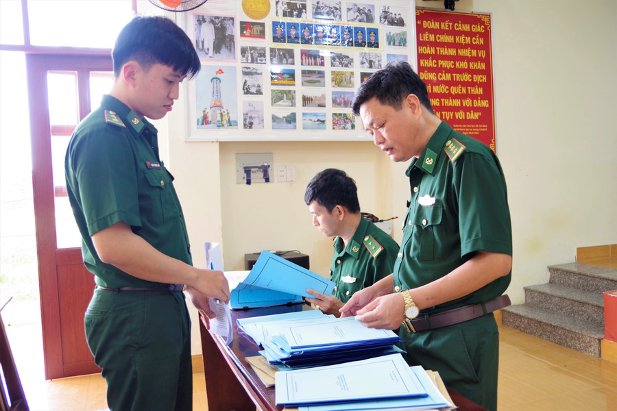 Thượng tá Trần Ngọc Tăng (bên phải) kiểm tra hệ thống các văn kiện về công tác huấn luyện chiến đấu và các kế hoạch về việc chống khai thác hải sản bất hợp pháp, không khai báo và không theo quy định năm 2023.