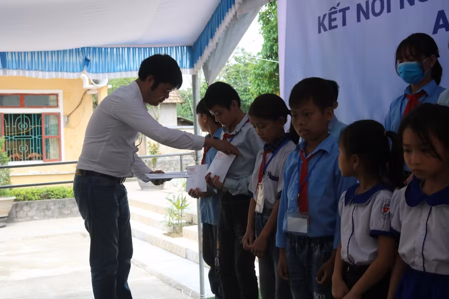 và nhà báo Nguyễn Văn Dũng, Trưởng Văn phòng đại điện Báo GD&amp;TĐ khu vực Bắc Trung bộ trao quà cho các em học sinh huyện miền núi Quảng Bình
