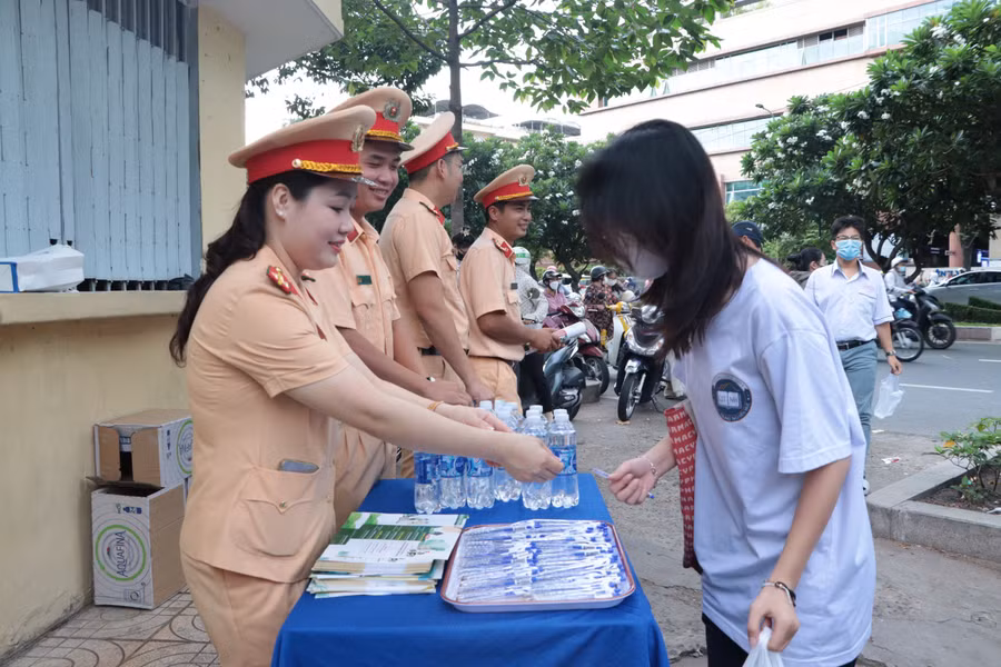 Tại điểm thi Trường THPT Hùng Vương, các thí sinh được cán bộ Cảnh sát giao thông phát nước và bút viết trước khi vào phòng thi.
