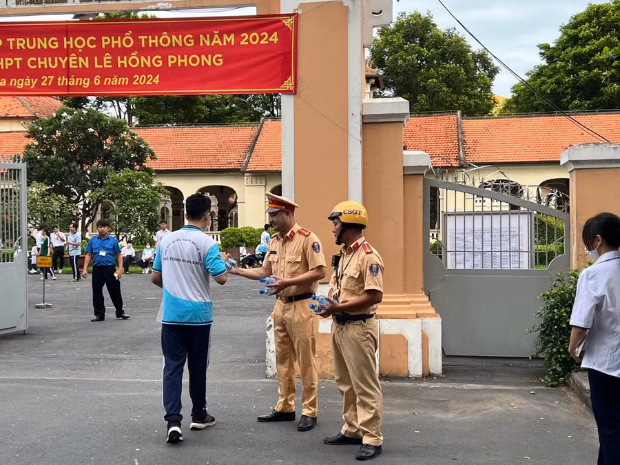 Cán bộ Cảnh sát giao thông phát nước cho thí sinh tại điểm thi Trường THPT chuyên Lê Hồng Phong (quận 5).
