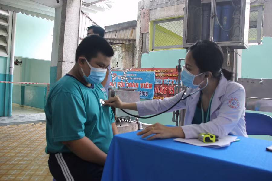 Nhân viên y tế khám sàng lọc trước khi tiêm cho học sinh lớp 6 trường THCS Nguyễn Tri Phương.