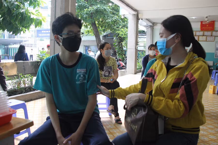 Chị Lưu Vân cùng con trai đến điểm tiêm từ sớm.