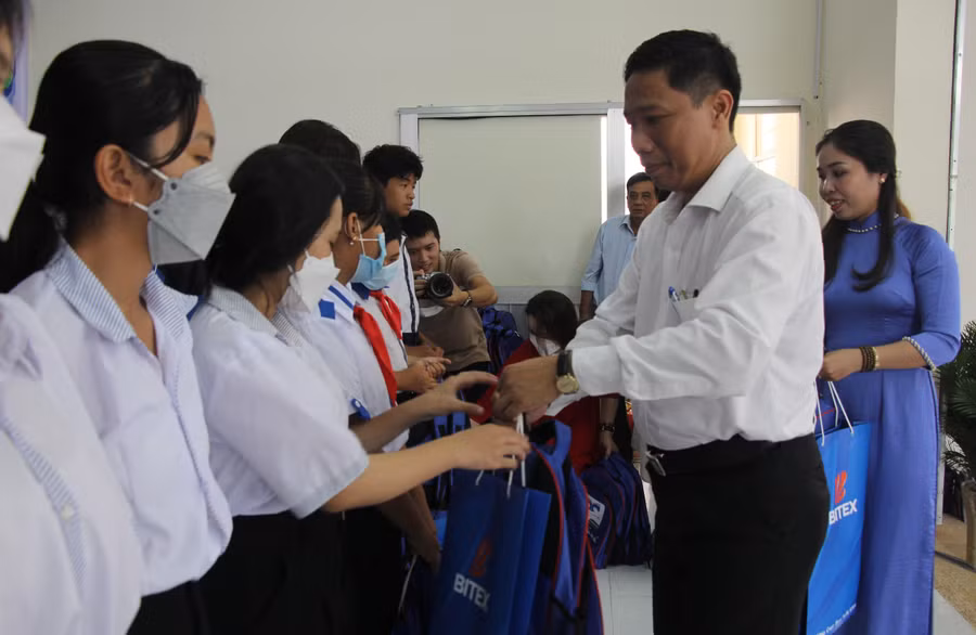 Ông Nguyễn Thực Hiện trao quà cho các em học sinh.