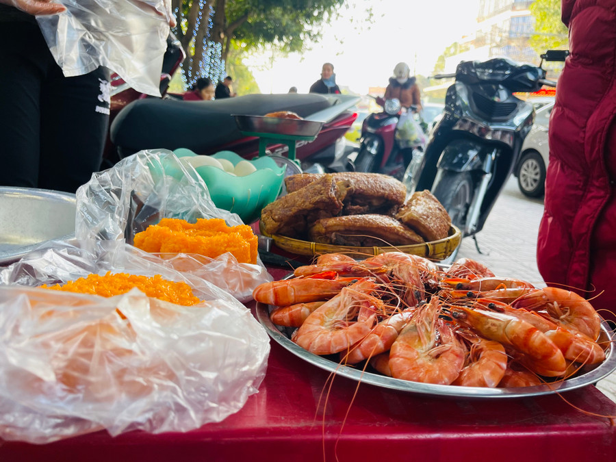 Bên ngoài các tiệm vàng, nhiều vật phẩm thắp hương lấy may như xôi gấc, thịt quay, tôm, trứng vịt... cũng được bày bán.