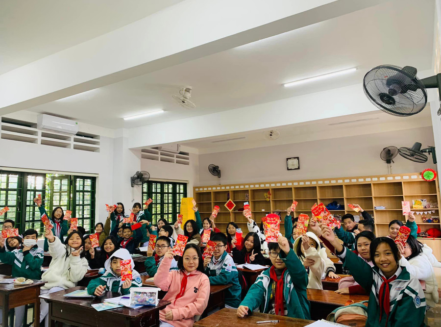 Học sinh Trường Lê Văn Thiêm thích thú nhận lì xì trong buổi đầu học đầu tiên của năm mới.