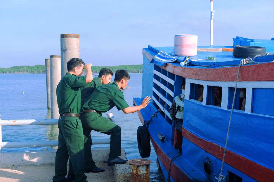 Cán bộ đồn Biên phòng Thạnh An động viên các thí sinh trước khi đò rời bến.