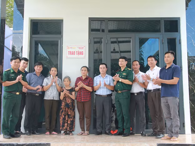 Các đại biểu kéo băng khánh thành, bàn giao nhà nhân ái cho bà Lê Thị Nuôi.