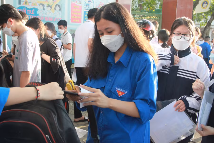 Các đoàn viên thanh niên hỗ trợ trông túi xách cho thí sinh tại HĐT.