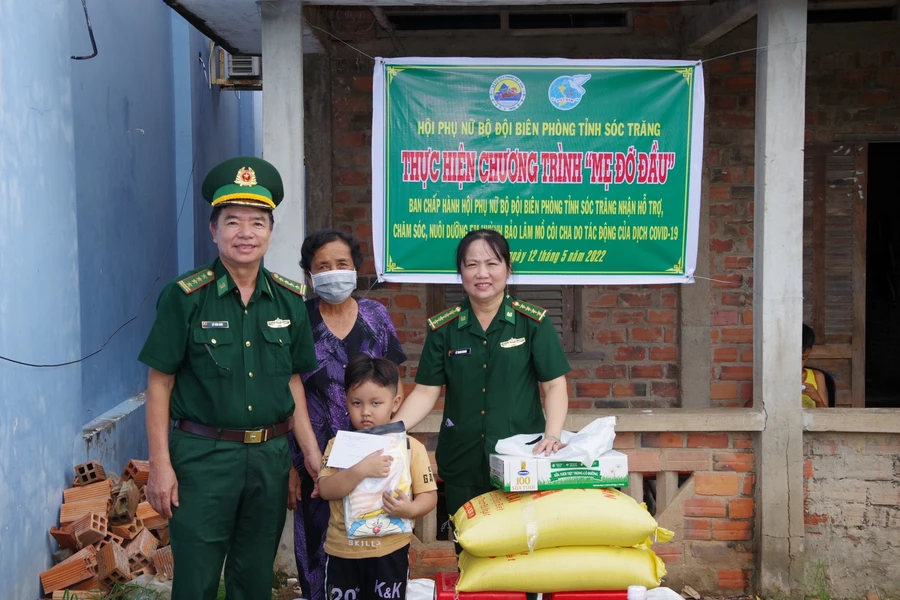 Đại tá Lê Văn Anh và Đại úyLê Thanh Nhanh, Chủ tịch Hội phụ nữ bộ đội Biên phòng Sóc Trăng trao quà cho em Lâm. 