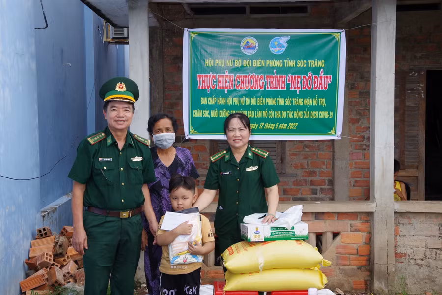 Đại tá Lê Văn Anh và Đại úyLê Thanh Nhanh, Chủ tịch Hội phụ nữ bộ đội Biên phòng Sóc Trăng trao quà cho em Lâm. 