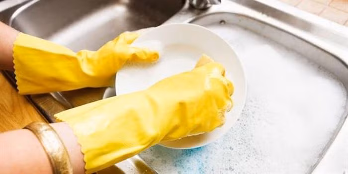 Đeo găng tay mỗi khi rửa bát hay làm việc nhà là cách bảo vệ móng tối ưu.