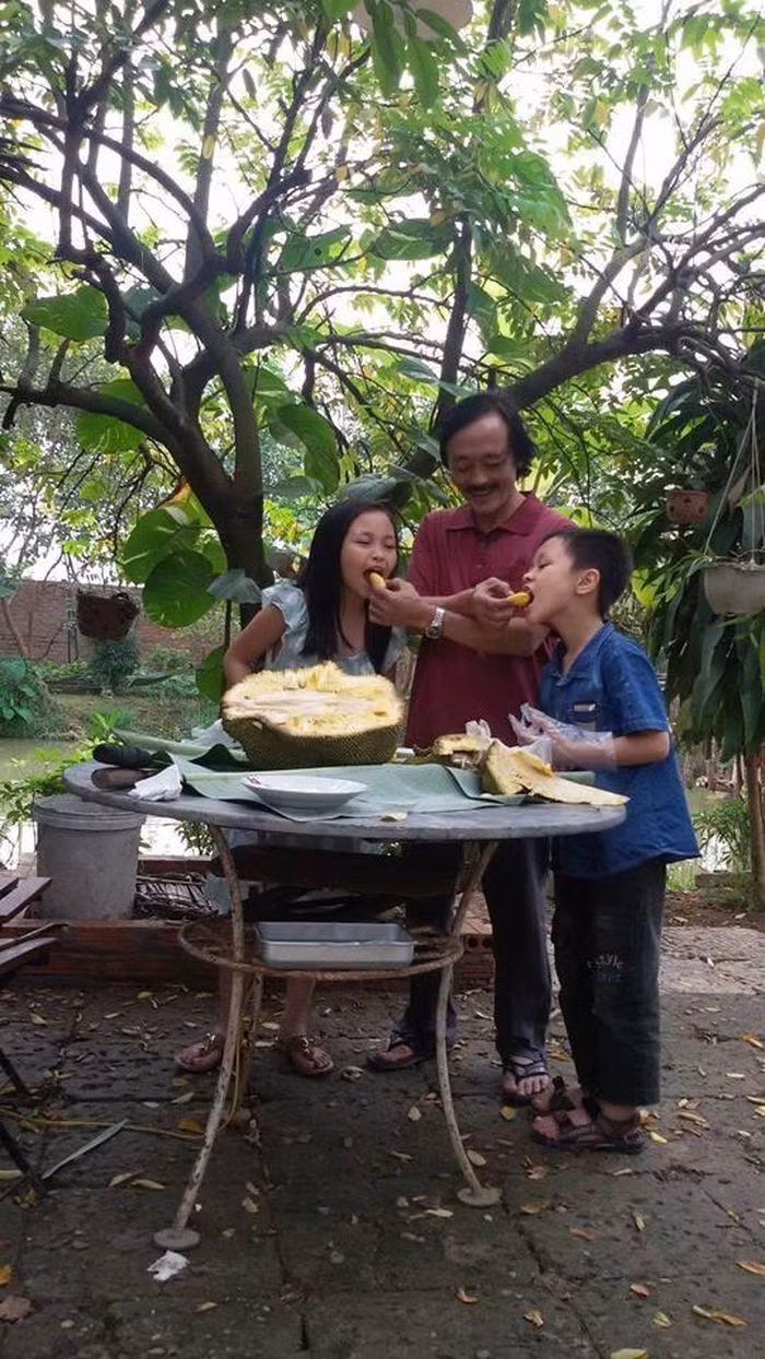 Ba bố con thích thú thưởng thức mít tại vườn.