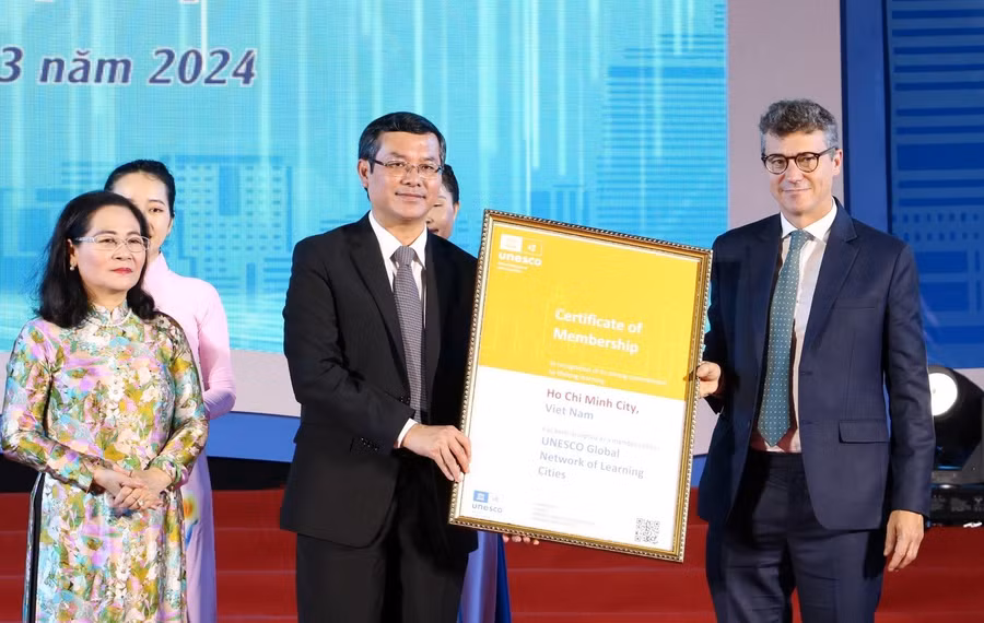 Ông Jonathan Wallace Baker - Trưởng đại diện Tổ chức Giáo dục, Khoa học và Văn hóa của Liên hợp quốc tại Việt Nam (ngoại cùng bên phải) trao chứng nhận thành phố học tập toàn cầu cho Ông Nguyễn Văn Phúc, Thứ trưởng Bộ GD&ĐT.