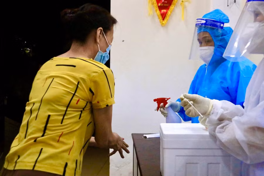 Sát khuẩn vệ sinh tay cho người dân trước khi lấy mẫu xét nghiệm.