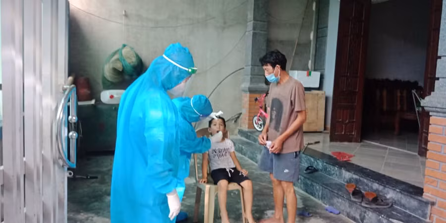 Cán bộ y tế lấy mẫu xét nghiệm cho người dân vùng phong tỏa.