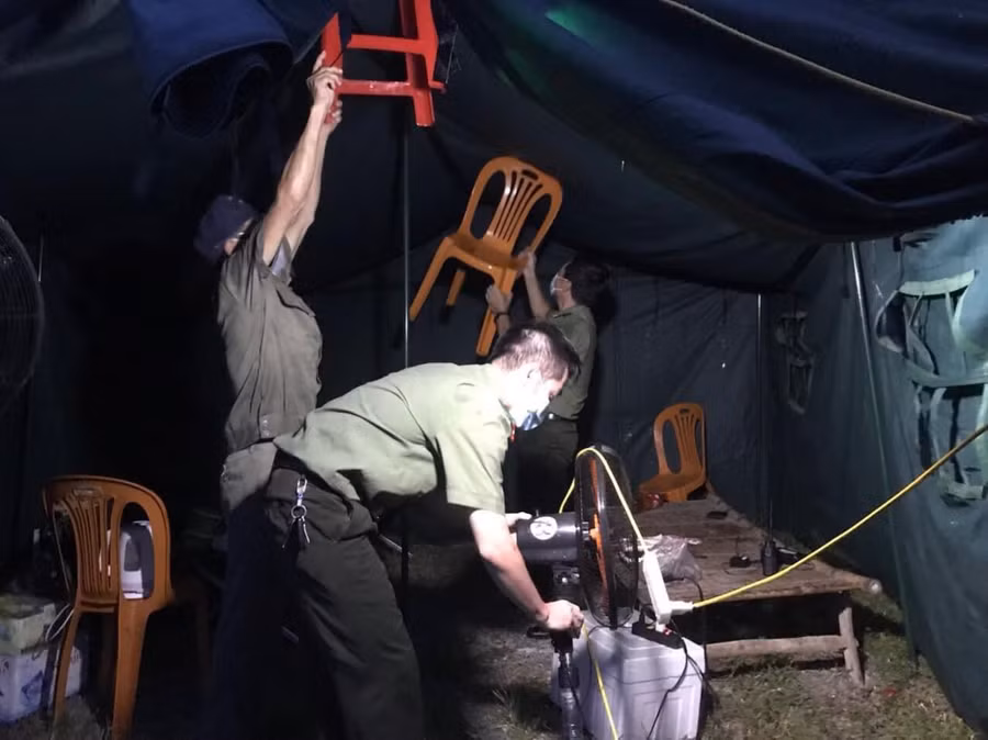 Cán bộ, nhân viên, chiến sỹ... vừa di dời đồ đạc vừa chống dột cho lán