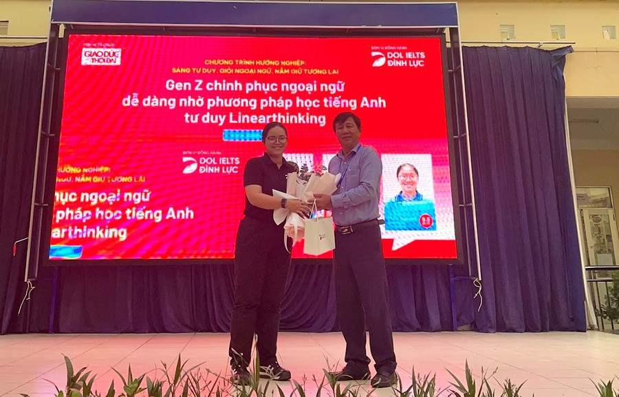 Cô Tô Ngọc Vy - đại diện DOL IELTS Đình Lực gửi tặng món quà tới BGH THPT Lê Trọng Tấn. Cô Tô Ngọc Vy - đại diện DOL IELTS Đình Lực gửi tặng món quà tới BGH THPT Lê Trọng Tấn.