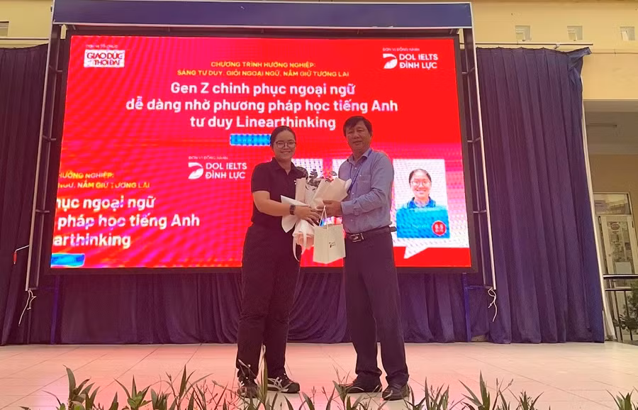 Cô Tô Ngọc Vy - đại diện DOL IELTS Đình Lực gửi tặng món quà tới BGH THPT Lê Trọng Tấn.