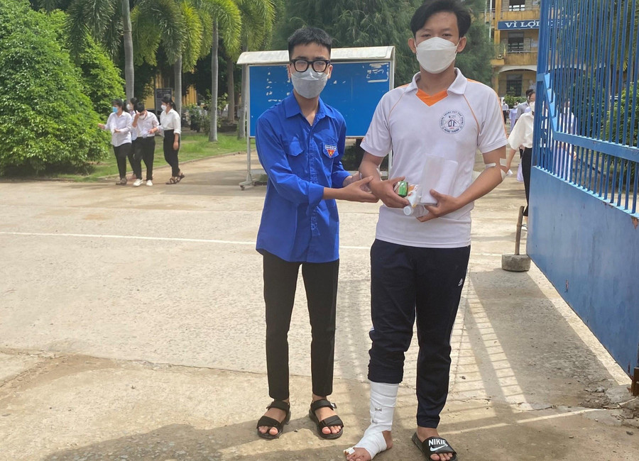 Thanh niên tình nguyện hỗ trợ thí sinh đến điểm thi THPT Đông Thạnh.