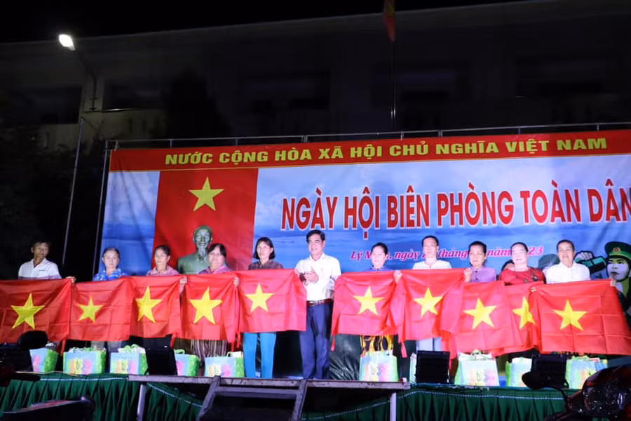 Tặng quà và cờ Tổ quốc cho bà con xã Lý Nhơn.