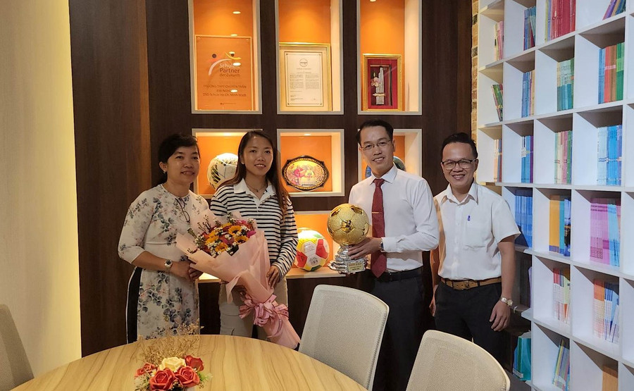 Huỳnh Như cùng Ban giám hiệu Trường THPT chuyên Trần Đại Nghĩa chụp hình tại phòng truyền thống của trường.