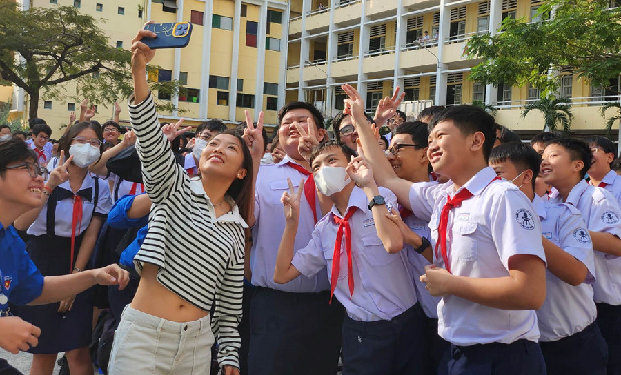 Huỳnh Như chụp hình với học sinh.