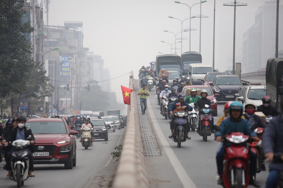 Theo ghi nhận của PV, khi đi bộ gần hết cầu, người đàn ông này bất ngờ nhảy qua lan can cầu xuống đất rồi tiếp tục cầm cờ chạy trên phố.