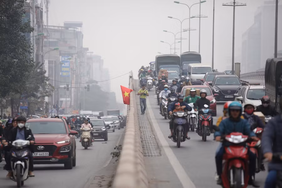 Theo ghi nhận của PV, khi đi bộ gần hết cầu, người đàn ông này bất ngờ nhảy qua lan can cầu xuống đất rồi tiếp tục cầm cờ chạy trên phố.